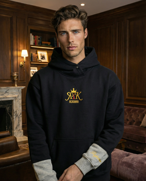 Model wearing a black hoodie with Rajkumarr logo on the chest, standing indoors.