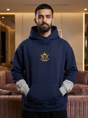 Male model wearing Rajkumarr signature navy blue hoodie with gold embroidered.