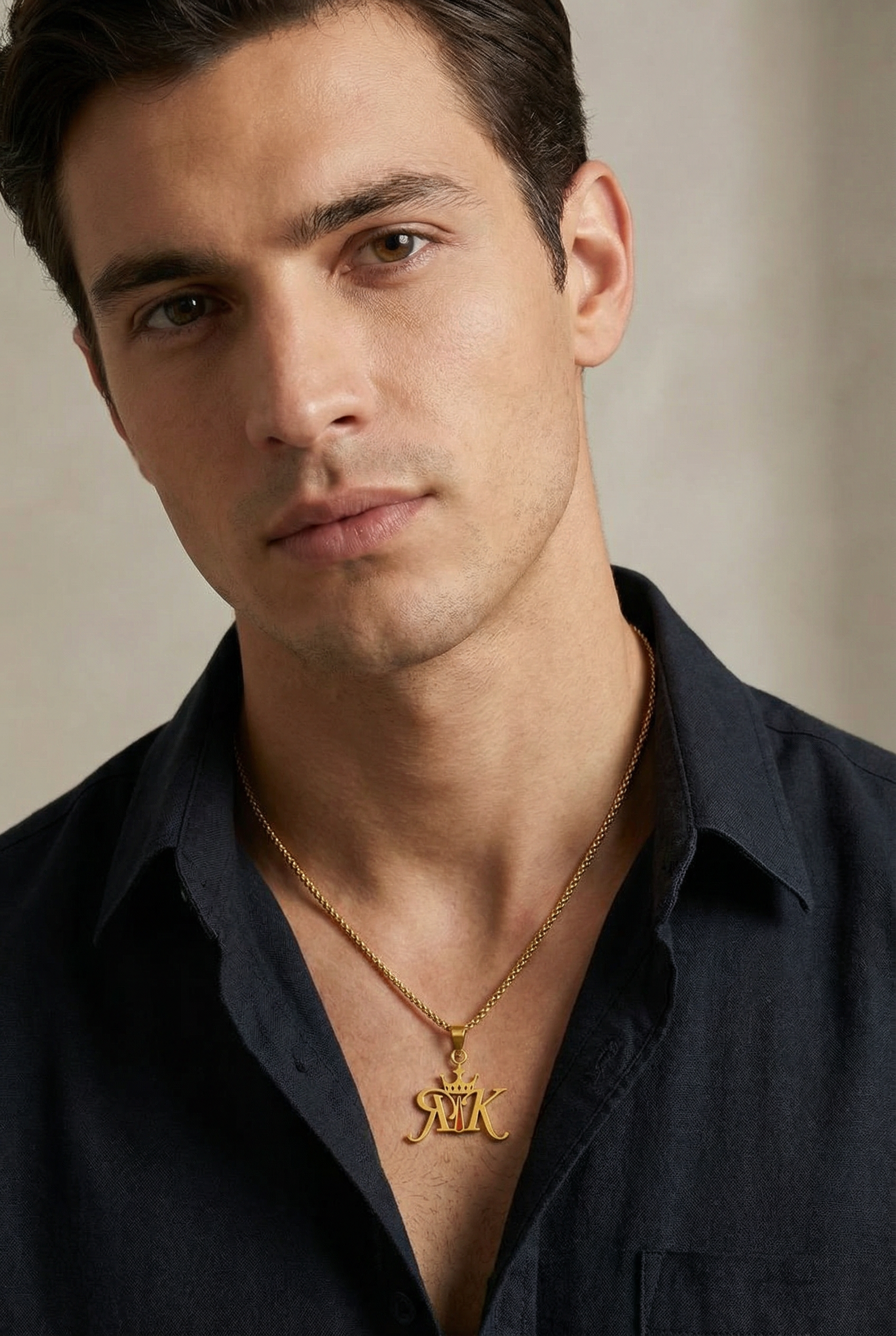 Stylish male model wearing the Rajkumarr signature RK pendant necklace, showcasing the pendant on chest with focus on jewellery and a luxury lifestyle aesthetic
